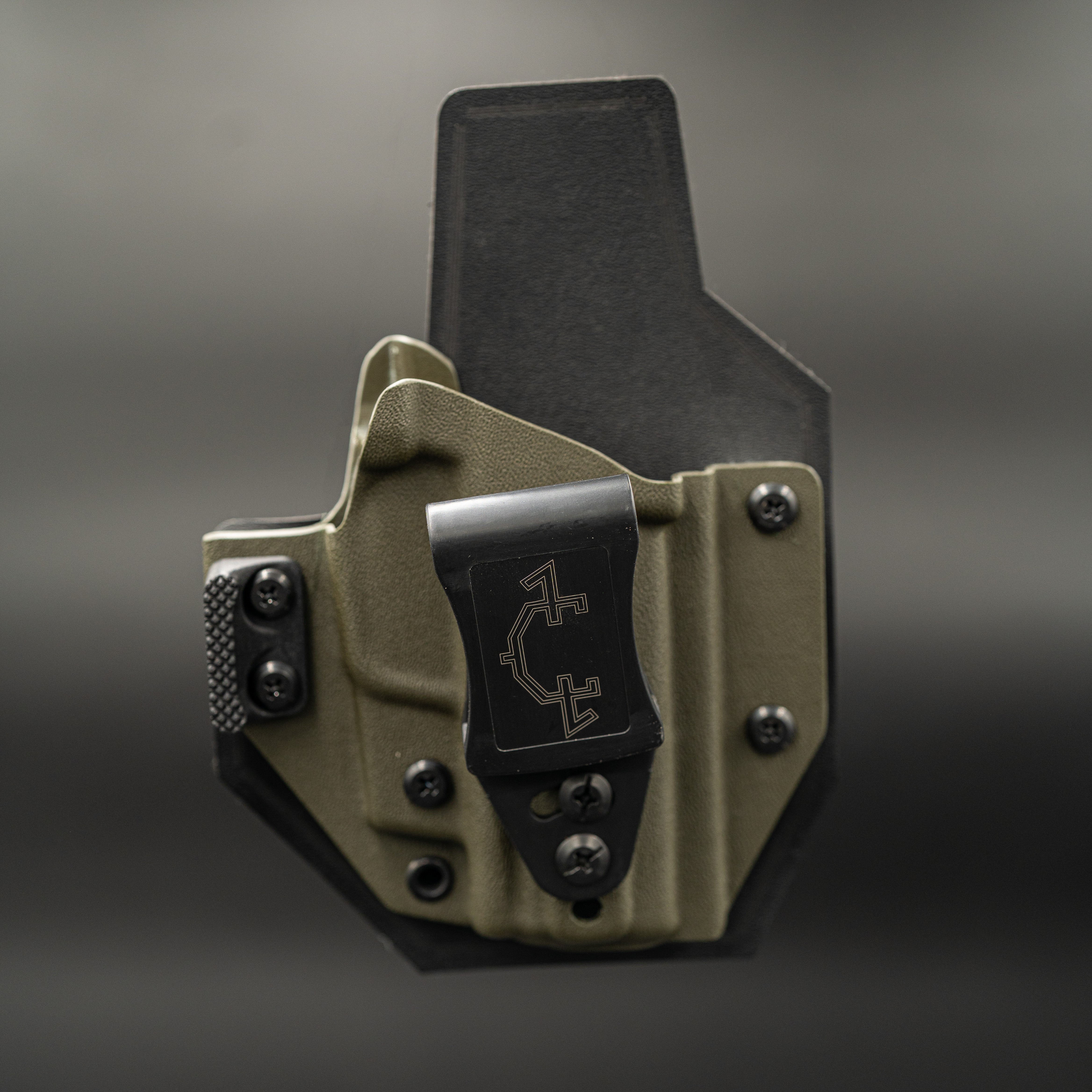 OD green and black outlaw IWB(inside the waistband) holster with a visible brand logo on a gray background