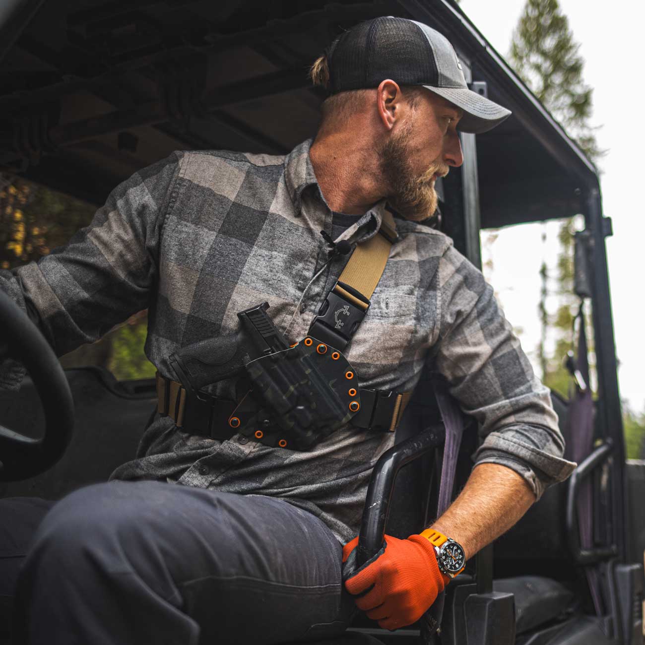 Person wearing a recon chest holster while riding a side by side