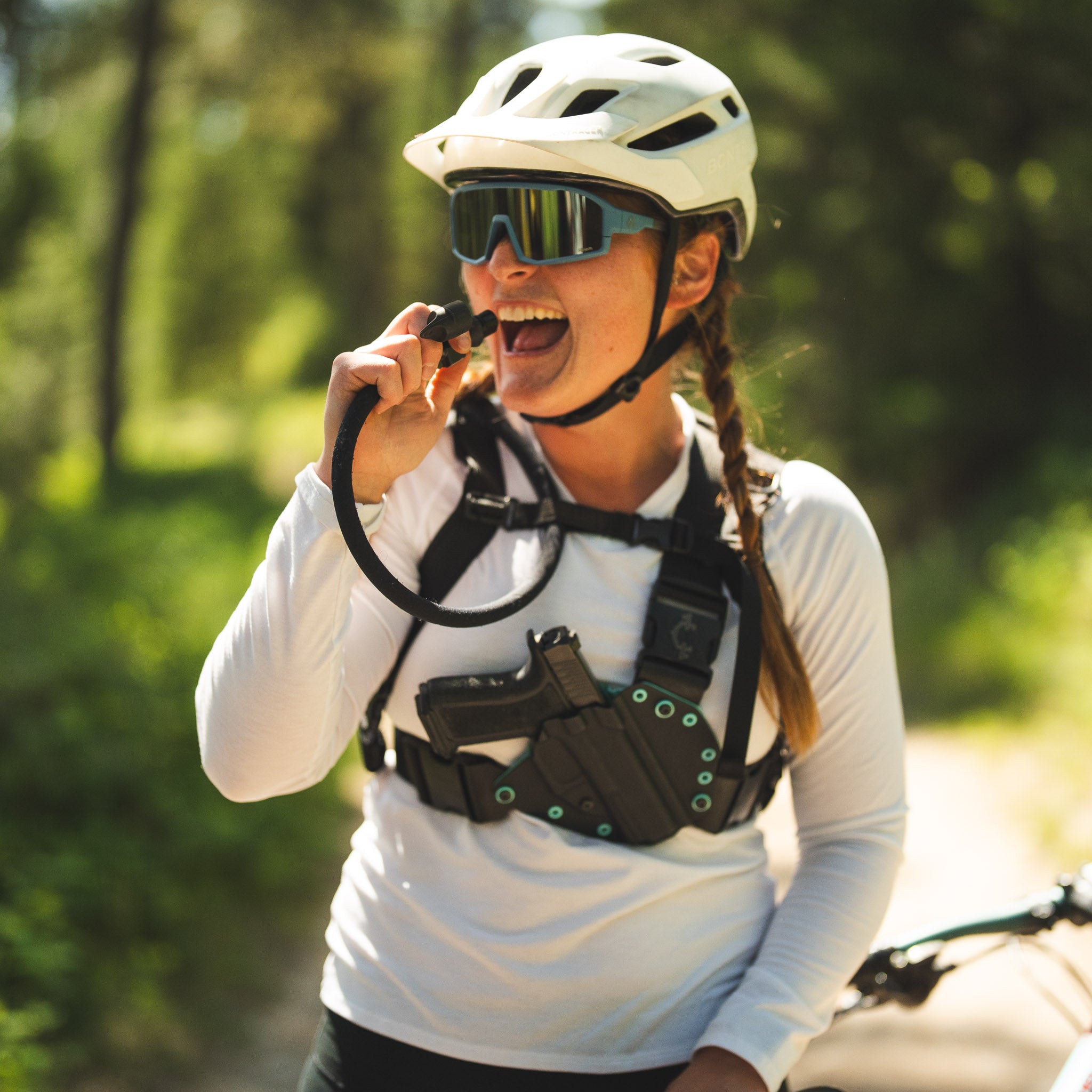 Woman wearing a helmet and safety gear outdoors and wearing a ladies recon chest holster