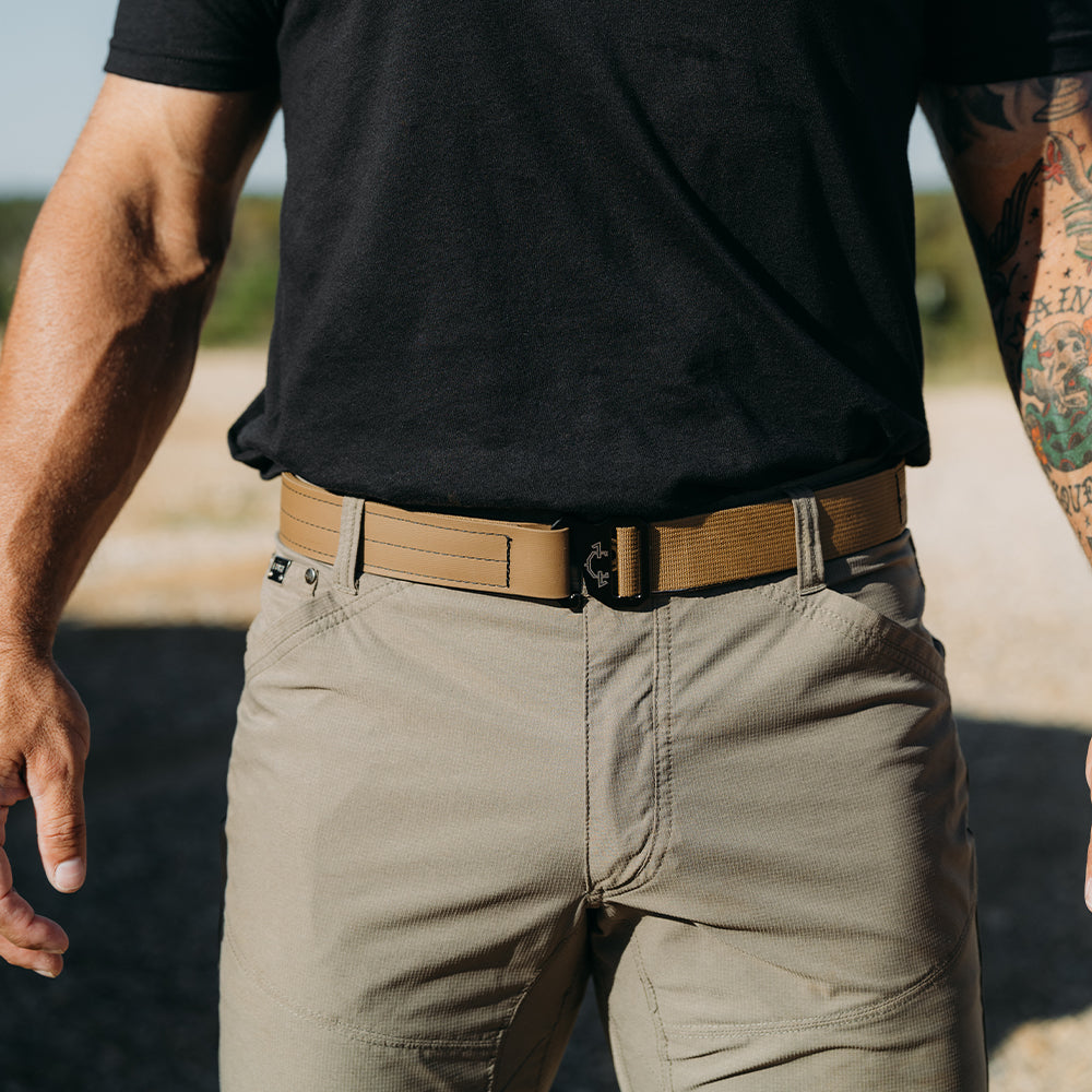 Person wearing a black t-shirt, beige pants, and a coyote edc(everyday carry) belt outdoors.