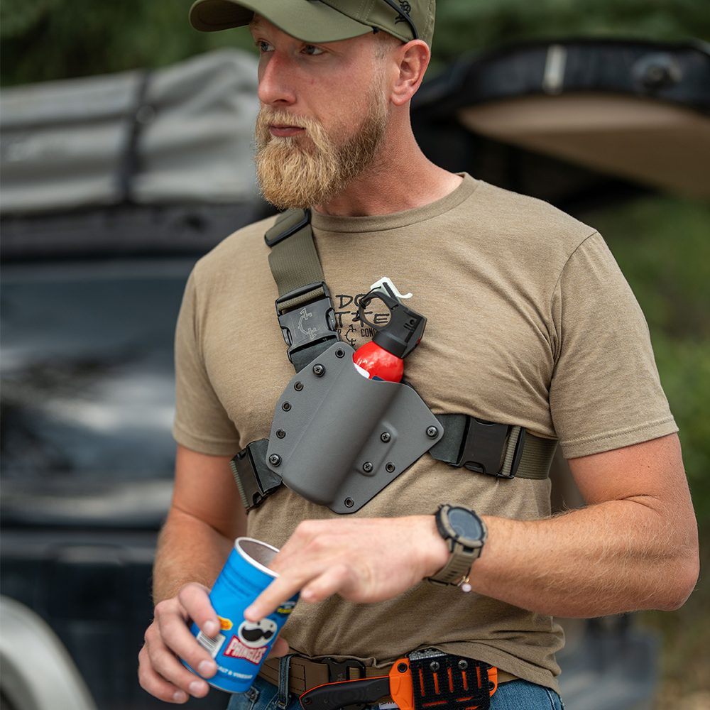 man with bear spray chest holster and blade lok eating pringles.