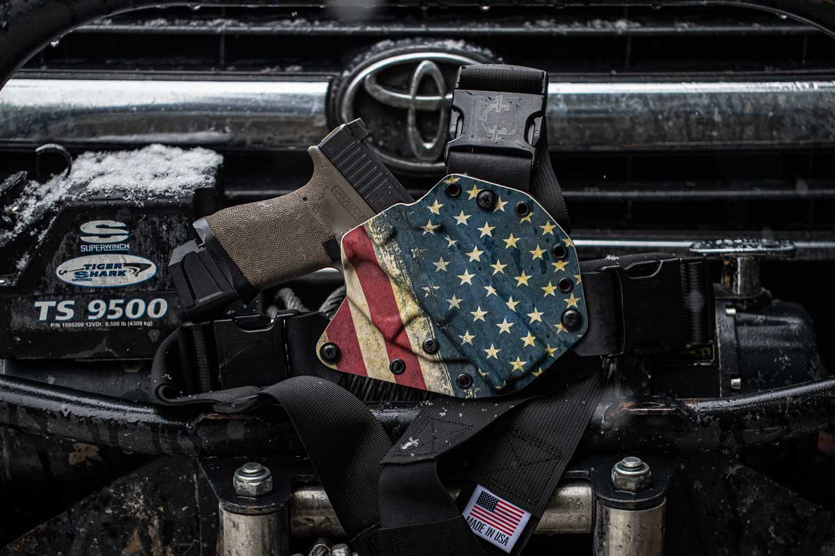Image of an American flag design recon chest holster in front of a Toyota car logo