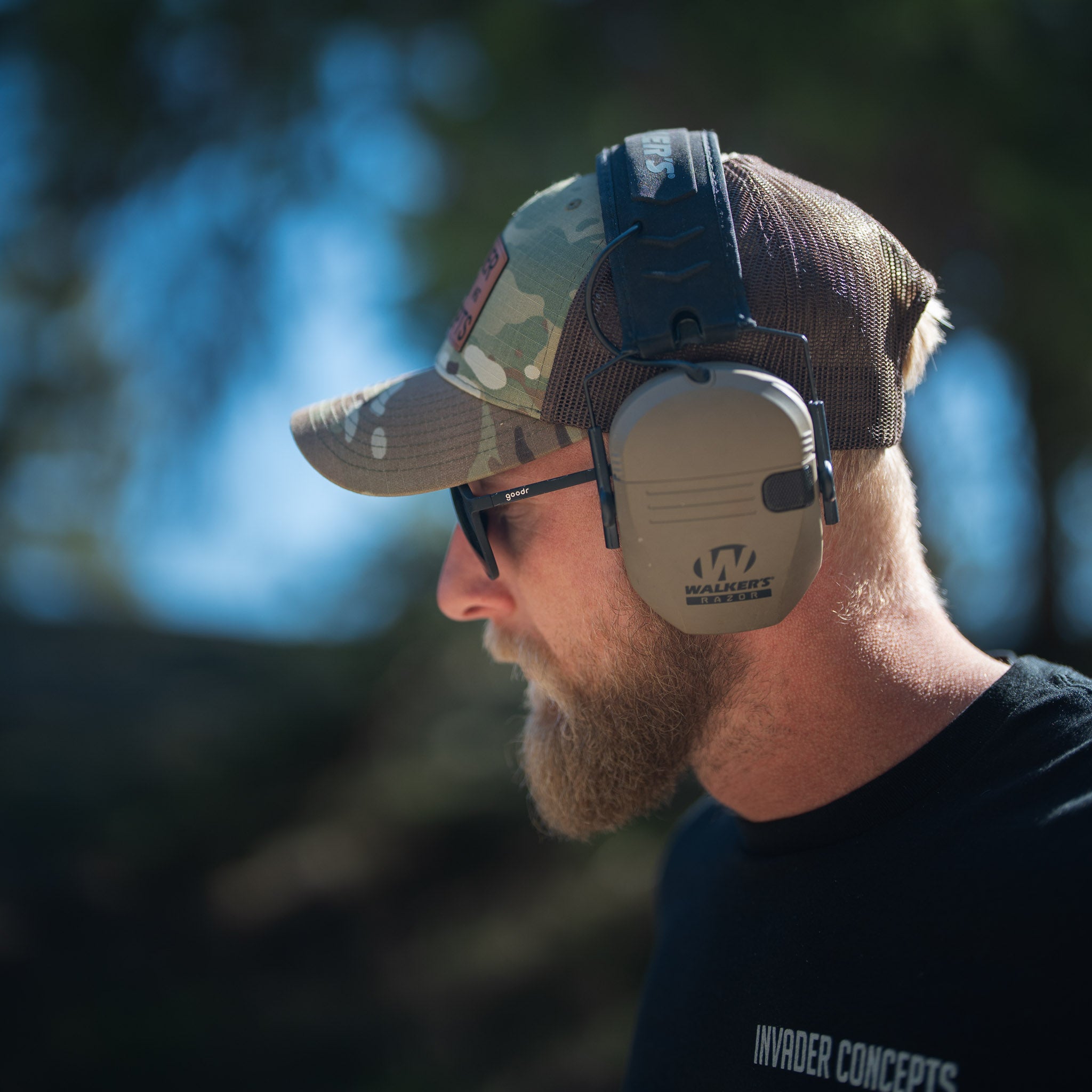 Man wearing a cap and ear protection with a blurred natural background