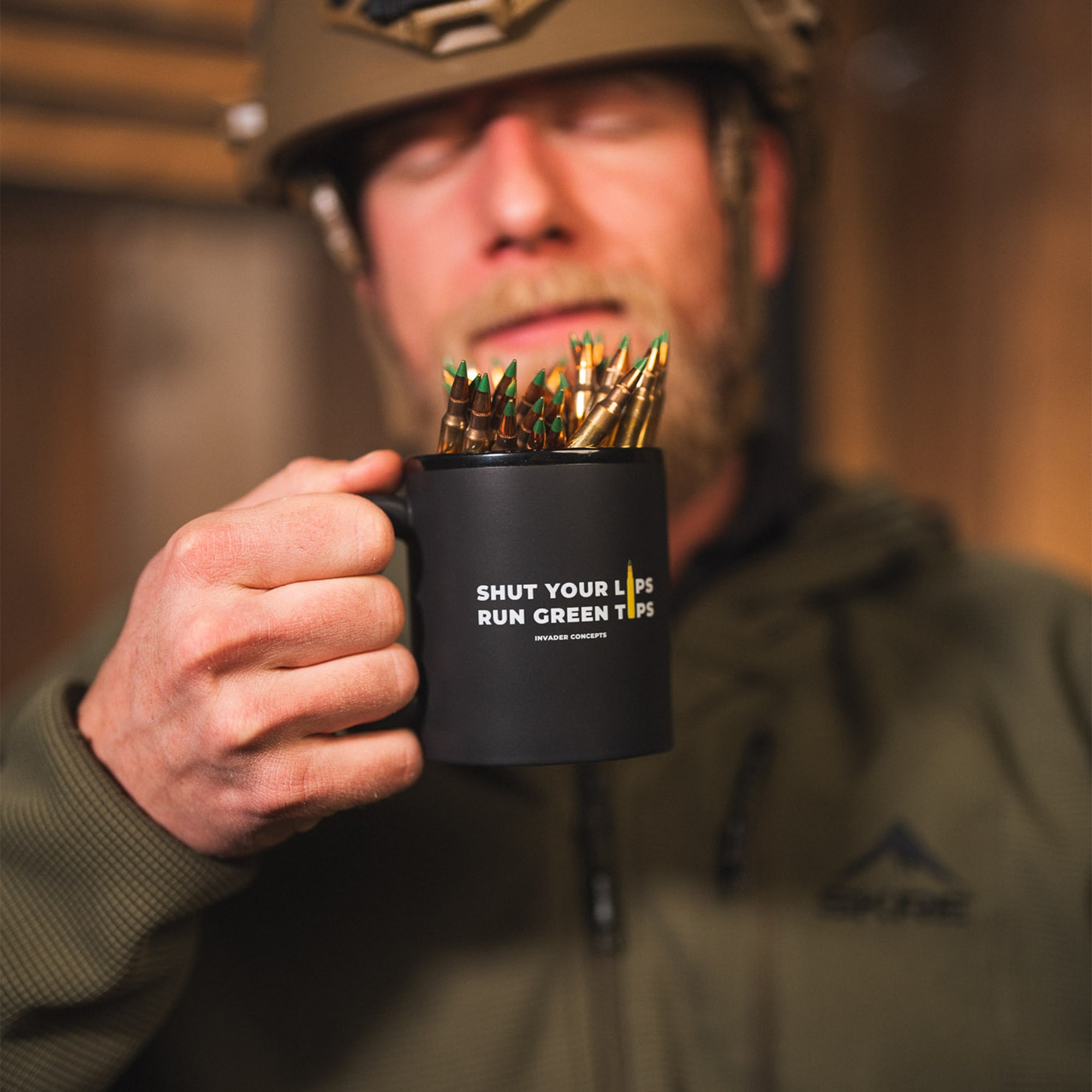 Person holding a mug with bullets and 'Shut Your Lips Run Green Tips' text