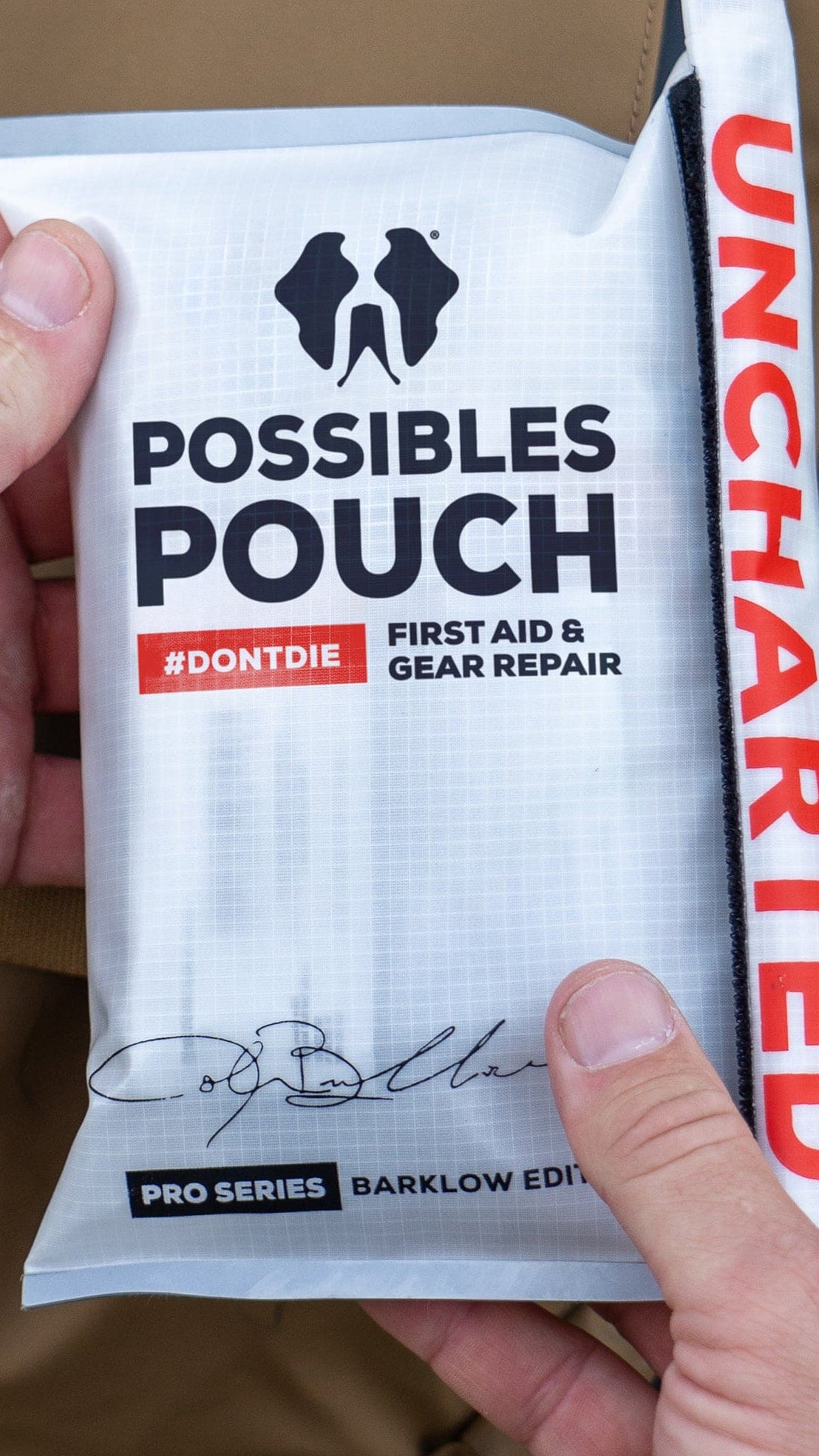 Person holding a 'Possibles Pouch' first aid and gear refuel package with 'Uncharted' branding.